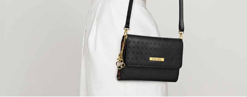 Black quilted handbag with gold accents on a white background